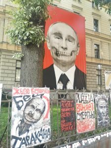 A sign in front of the Russian embassy in Riga. Picture of Putin that looks like a skull. Under the picture signs that say, “Long Live Belarus without the cockroach (Lukashenka)”, “The blood of Ukrainian children is in your hands” and “Ruzzian world smells like death”.