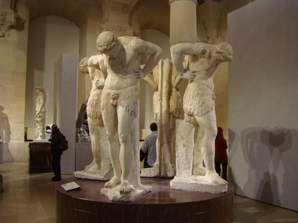 Three marble statues depicting people who gaze at their navel