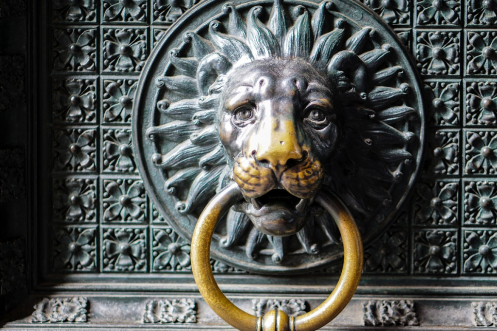 Photo of a door knocker made of metal and shaped like a lion