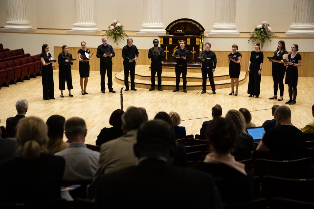 A twelve person choir sing during an interval.