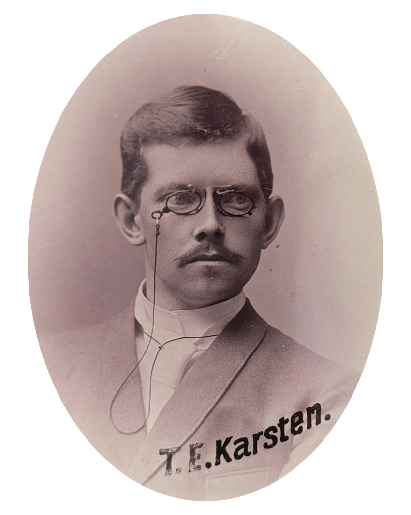 An oval photo of a fairly young man with a moustache and pince-nez glasses.