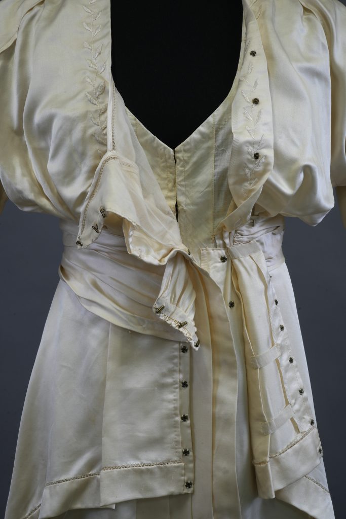 A close-up of the outfit on a mannequin, with the front opened so that the cotton lining can be seen at the neckline.