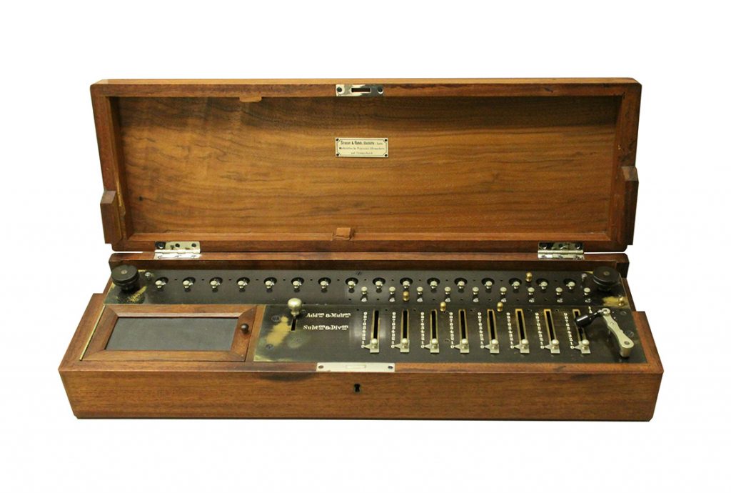 A metal calculator in a wooden box.