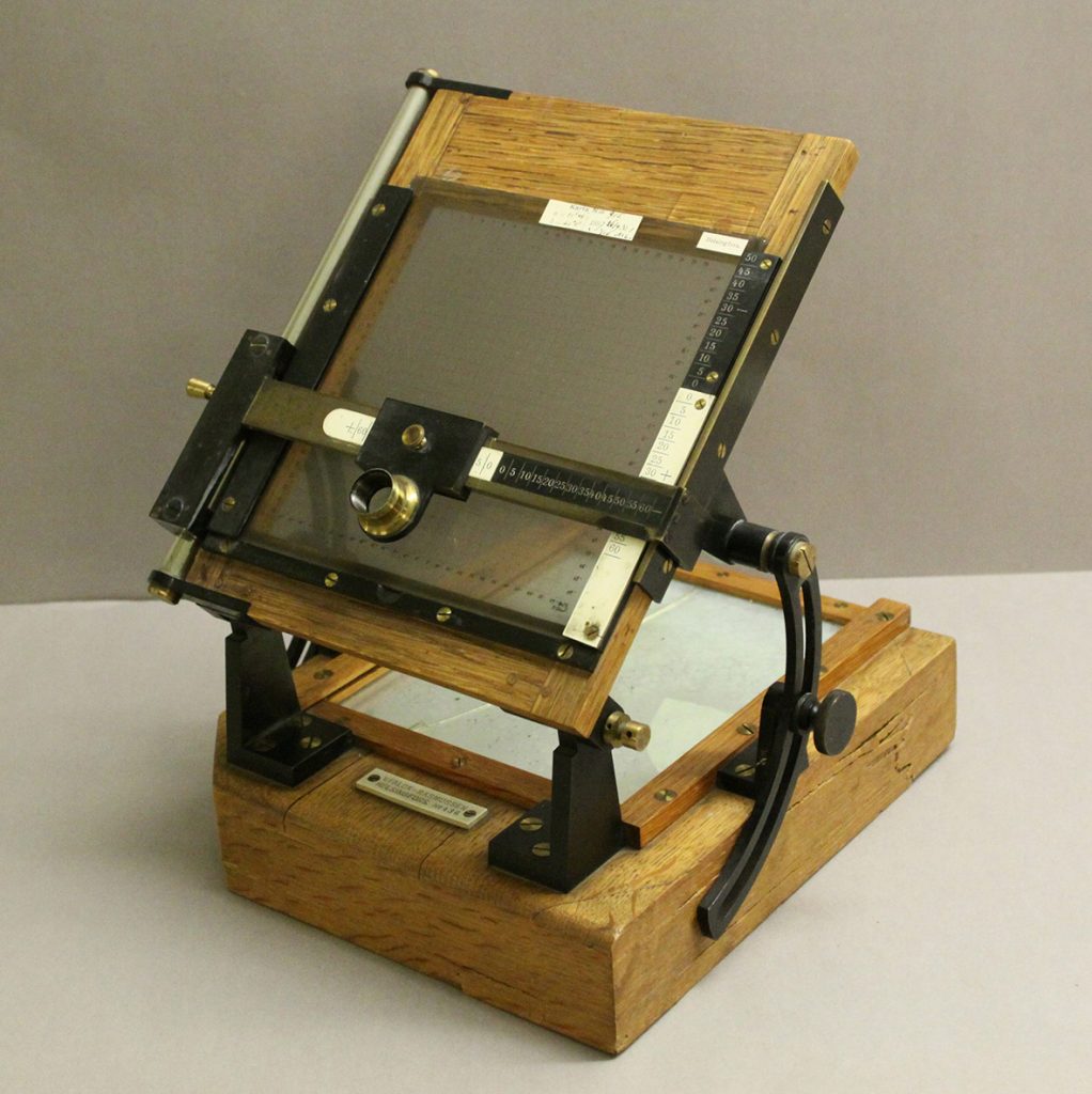 A wooden stand displaying a photographic plate ready for examination.