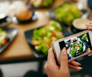A person taking a picture of salad