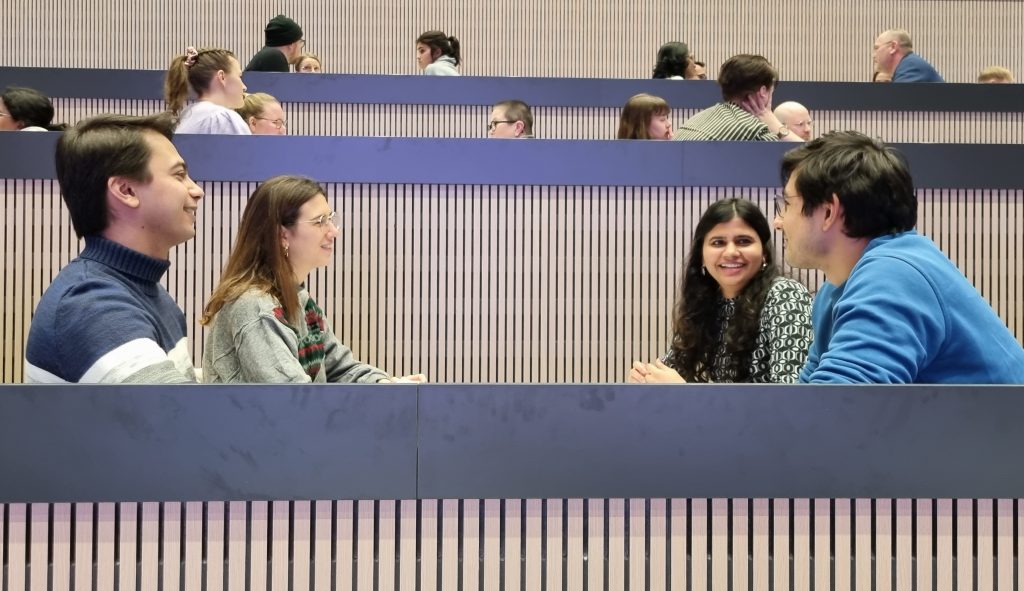 Jutussa haastateltu nelihenkinen Sangita Seshadrin mentorointiryhmä istuu Viikin Oppimistorin keskellä pöydän ääressä juttelemassa.