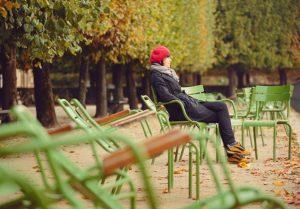 Woman sitting on a bench in a park. 