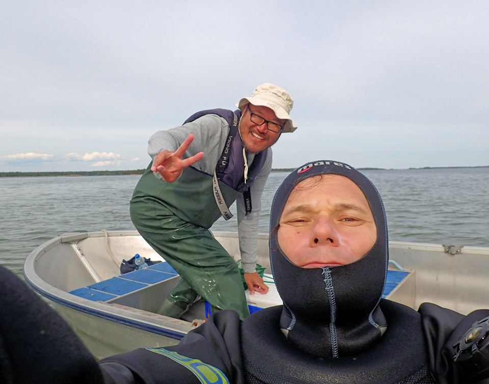 Dr. Topi Lehtonen and Associate Professor Bob Wong on a small boat doing a selfie.