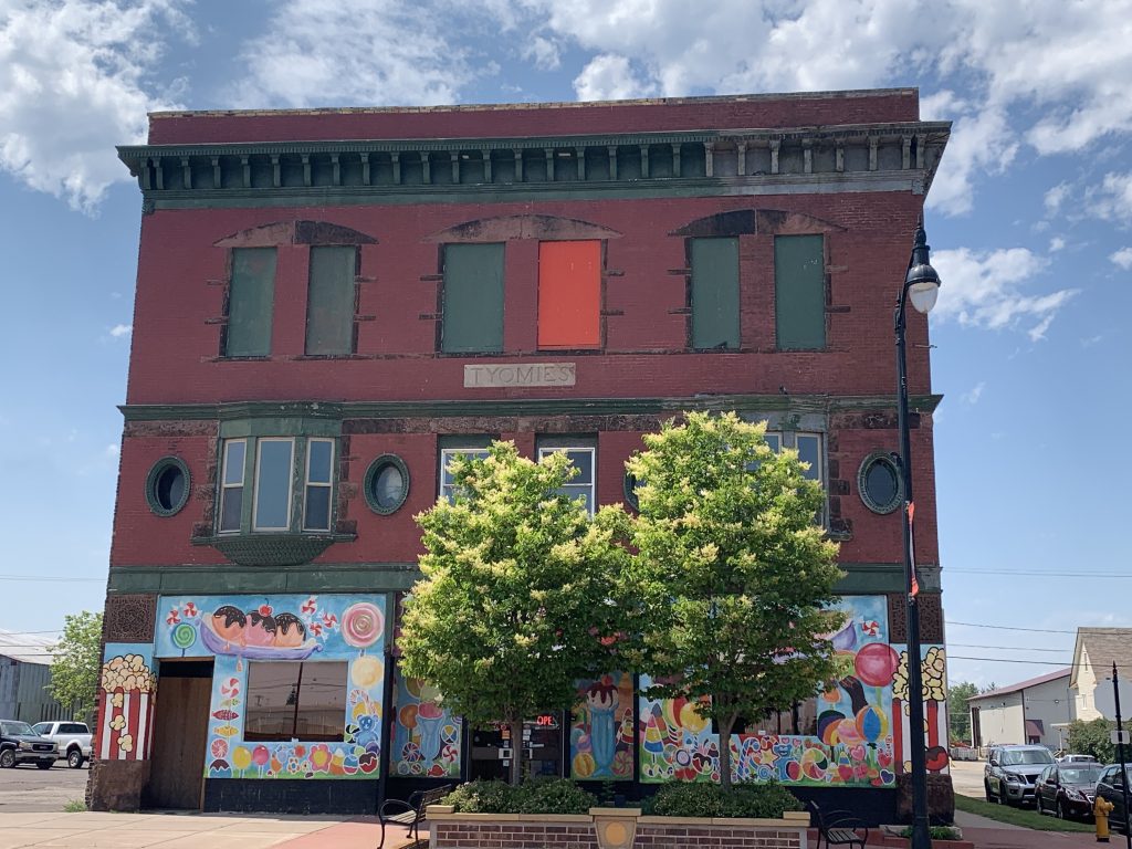 Red brick building, bright decorative candy and sweet images painted on the walls of the bottom floor.