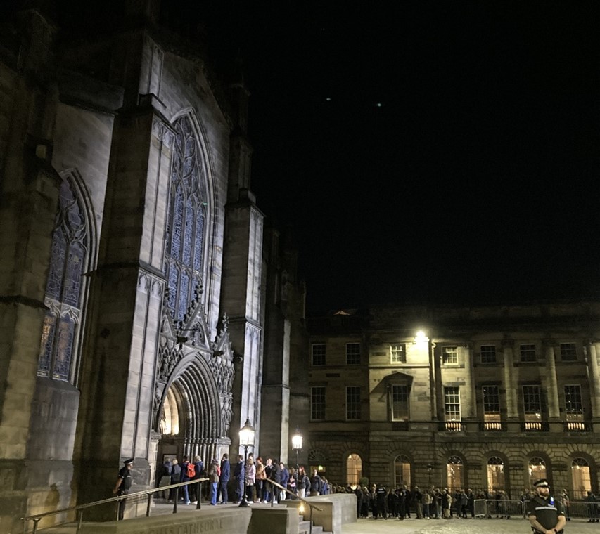 Ihmisiä jonottamassa St Gilesin katedraaliin kunnioittamaan edesmenneen kuningatar Elisabet II:n muistoa illan pimennyttyä 12. syyskuuta 2022.